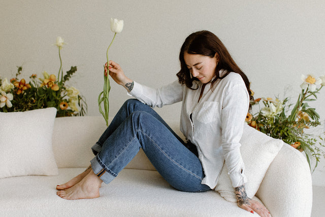 Southern California Floral Designer holding tulips on white couch in costa mesa california